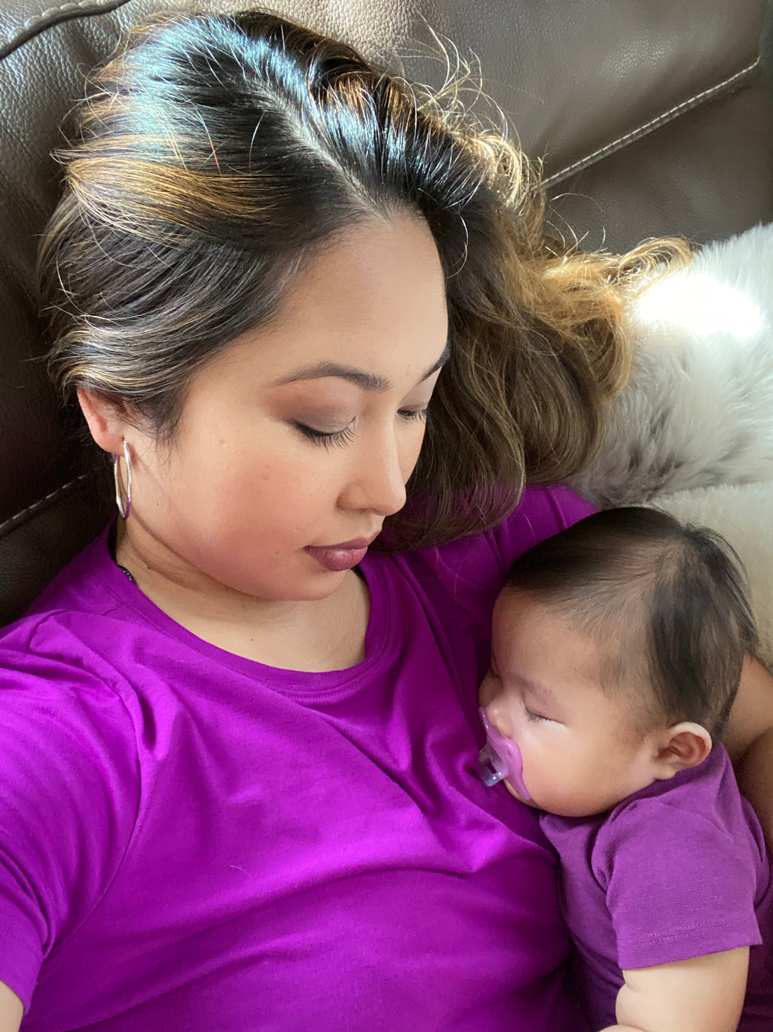 A soft glow highlights the mother's contemplative  gaze downward, reflecting the emotional depth and authenticity of self-care and maternal bonding.